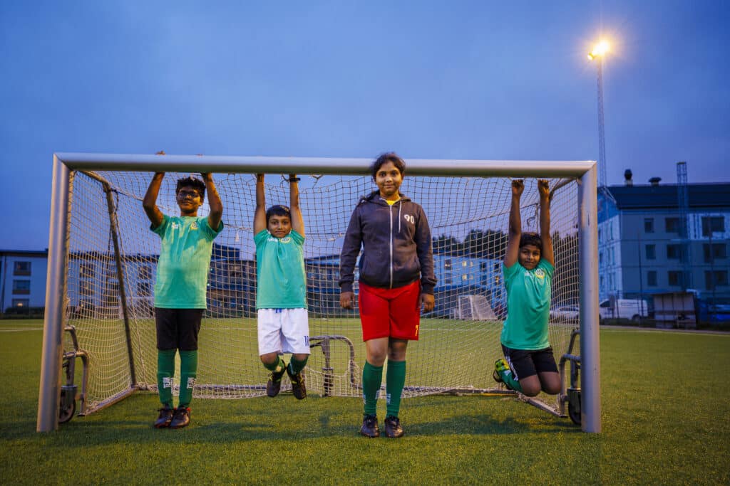 A good new life in Boden. Indian children play football in Boden's colors.