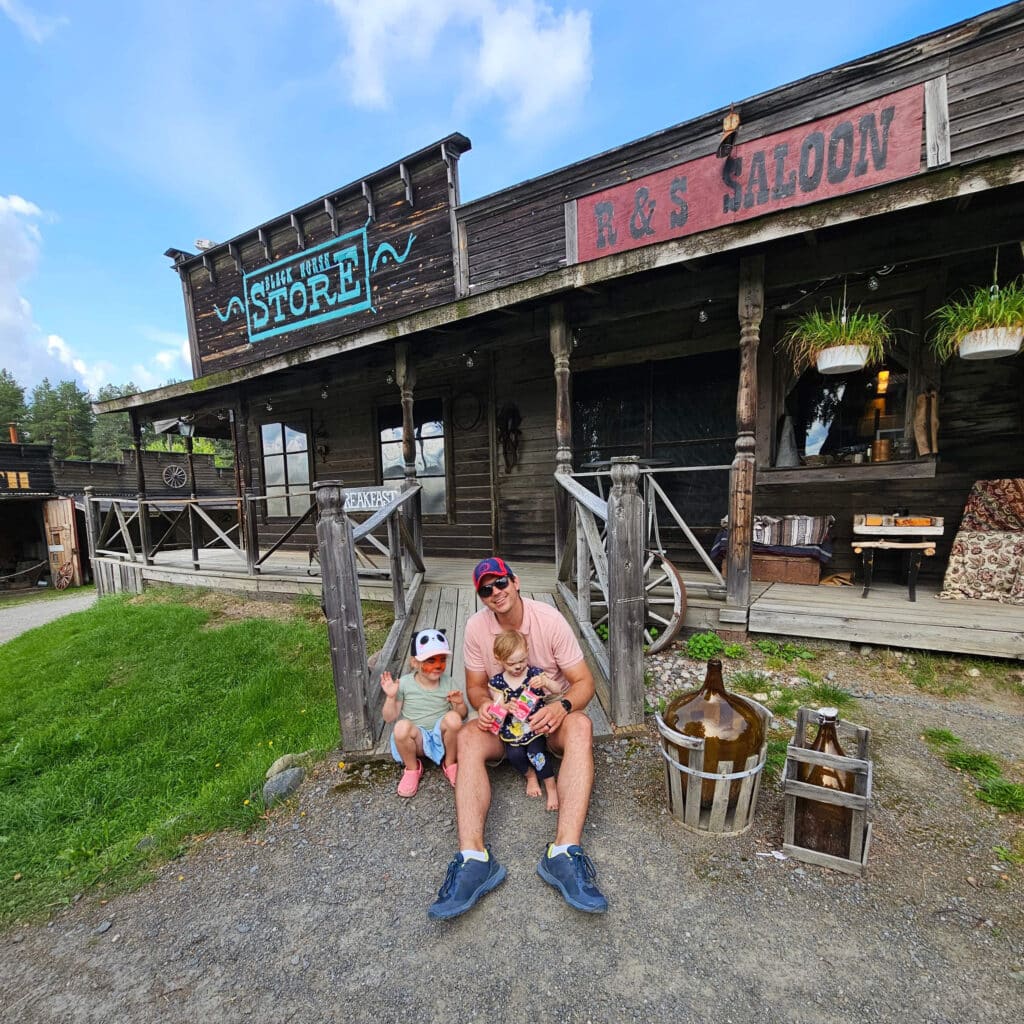 Father and child sitting on the steps of the Western Farm amusement park