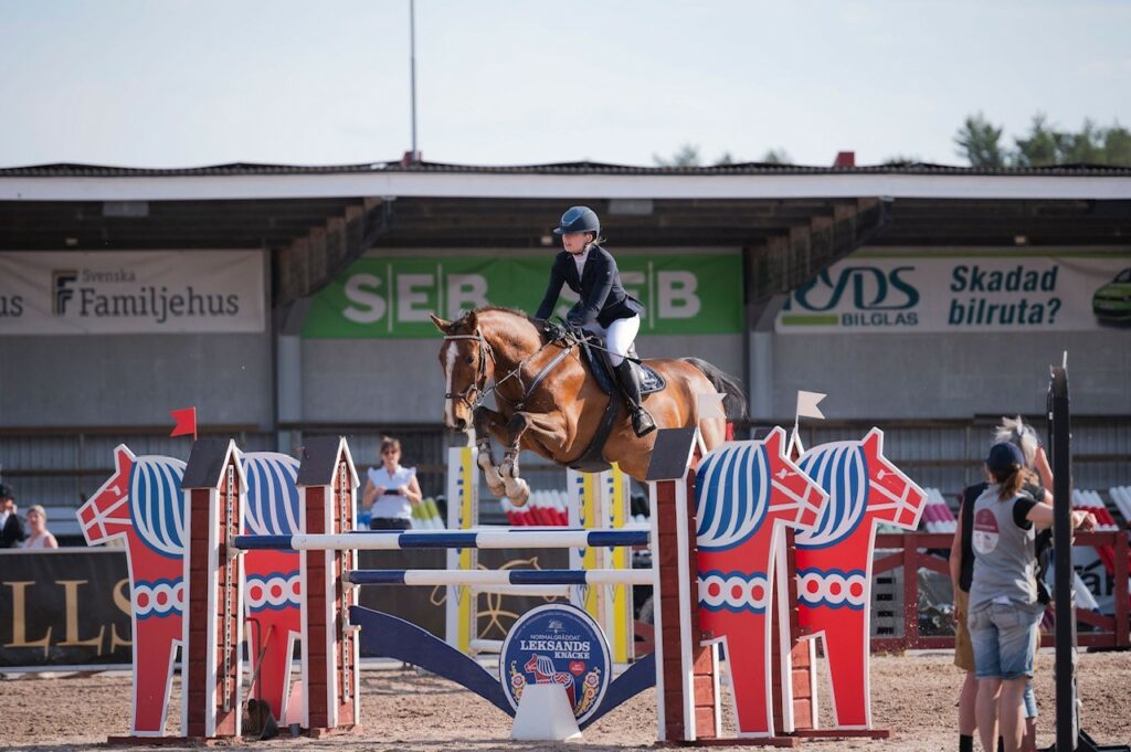 Nina and her horse Uno at a jumping competition. Jumping over obstacles. Private picture.  